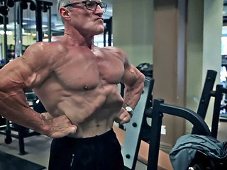 Ripped mature bodybuilder flexes muscles and shows off veins