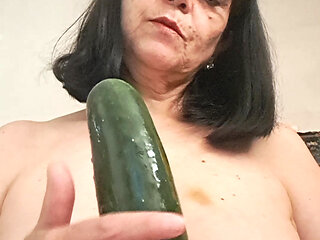 MILF playing with her tits and a cucumber, wetting it with her tongue