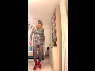 Beautiful Spanish trans woman poses seductively in the living room wearing high red heels and a sexy dress