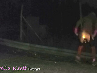 Exhibition at night in safety access off the A7 motorway. lighting anal plug and caged cock