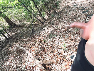 A boy with a small foreskin pees a huge stream outdoors