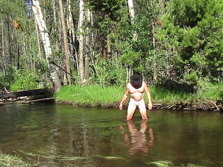 Bathing naked in the creek.