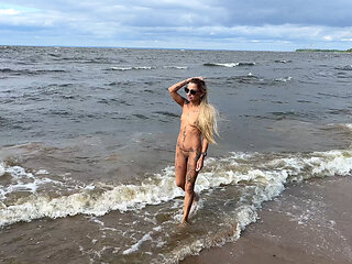 Beauty blonde walking naked on the seashore