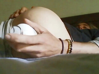 Young man pleasures himself in his bed