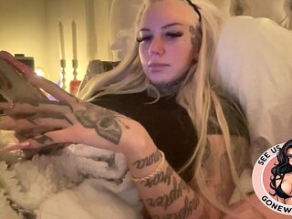 Inked Blonde Bombshell Holding Toys in Bed