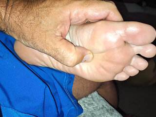 Giving her  a soft foot rub and massage on the couch