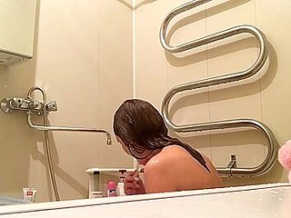 in the bathroom filming hot MILF taking shower