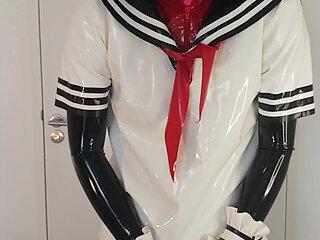 Putting on latex Japanese schoolgirl sailor uniform and long gloves over rubber dress, long skirt and corset, layers