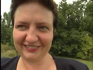 Lovely mature lady blows a guy's cock outdoors near the car