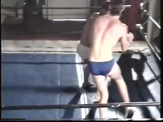 Two young men wrestle close in ring
