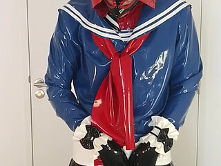 Putting on another latex Japanese schoolgirl sailor uniform and cuffs over rubber dress, layers