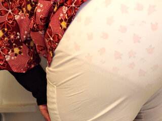 Molly is peeing her white nursing scrub pants.