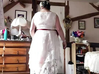 In an outfit with a long white lace dress styled like a wedding dress for an evening.