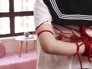 Gg50 - Cute Girl Challenges Herself to Break Free From the Restraints of Ropes and a Single Glove on the Bed.