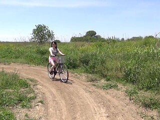 Removing her clothes while riding a bike outside
