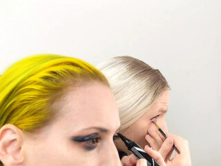 Crossdresser and Woman Putting on Eyeliner