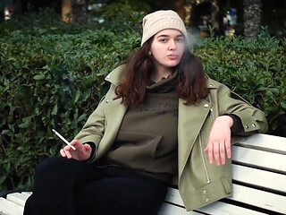 Young Brunette Is Taking an Unhurried Stroll with Allwhite 120mm Cigarette