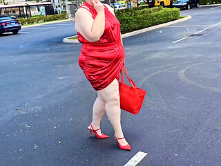 Beautiful woman walking outdoors in public parking lot showing off for strangers