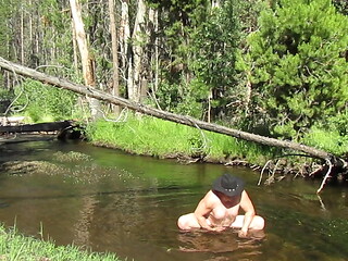 Bathing naked in the stream.