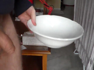 John is pissing in a bowl in closeup