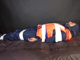 Sexy Sandra Being Tied And Gagged With Tape On A Bed Wearing Blue Rainwear And A Lifevest (Video)