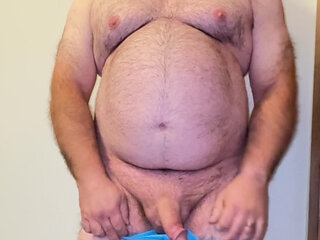 Anal Steve in his blue thong showing off his Bear body and cock, with a cock ring on and showing his massive butt plug