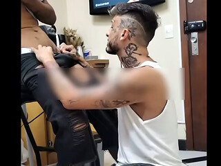 Ajoelhado na frente do cliente medindo o local da tatuagem