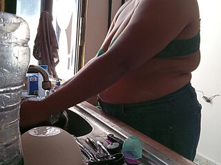 Mother-in-law cleans in the kitchen in bra