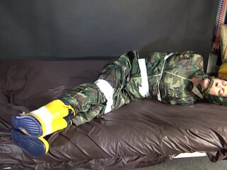 Watching Sexy Pia Being Tied And Gagged With Tape On A Bed Wearing A Sexy Camouflage Shiny Nylon Rainpants And A Rainjacket As Well As Yellow Rubber Boots (Video)