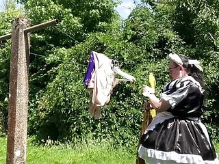 In a black and white maid outfit to hang out the laundry.