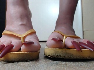 Close-Up Yellow Flip Flops with Hanging Toenails