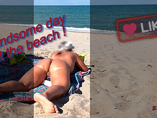 She shows her ass on the beach of Cap d'Agde and jerks off her pussy and then her boyfriend's cock with voyeurs