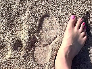 Comparing Size 16 Feet to Sand Prints at the Beach
