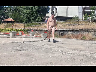 A boy completely naked in an abandoned courtyard
