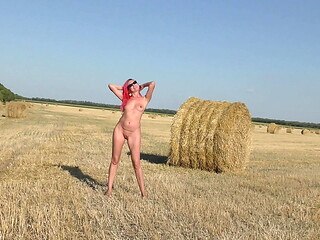 A naked girl moves rollers with hay!