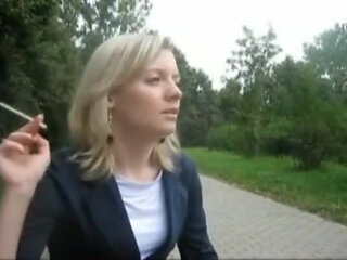 Blonde beauty smoking a cigarette outdoors