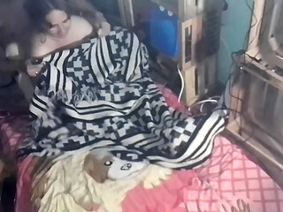 Under the blanket, couple kisses and touches each other