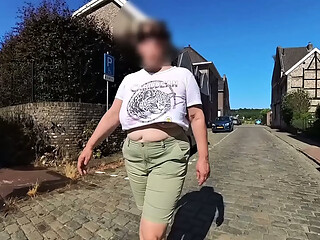 A busty milf walking in the street braless