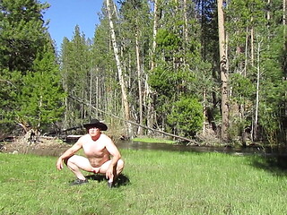 Kneeling naked at the river.