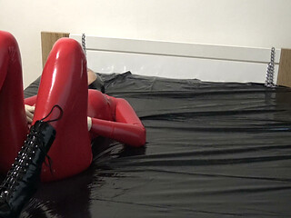 Photoshooting in Red Latex Catsuit with Latex Mask and Transparent Face.
