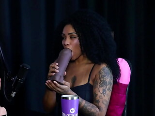 Negra safada mostra os peitos e demonstra seu boquete depois de falar que tem interesse em fazer fisting, e gosta de botar o cintaralho - Sara Ventur (SHEER/RED)