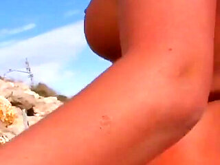 A slut with two soft breasts and blonde hair is ready for some ass fucking on the beach