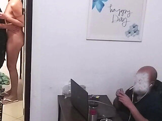 While the Husband Works, the Wife in a Towel Greets the Delivery Man