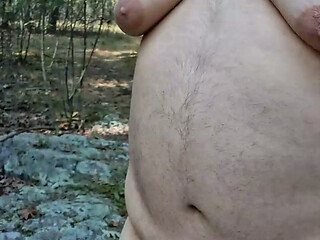 Chubby guy strips, leaves clothes behind and cums in the woods