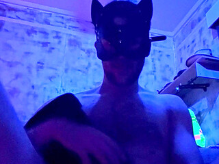 Putting leather boots on in a leather mask