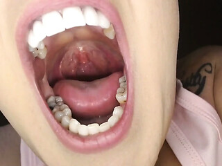 Closeup on teeth and tongue during hot oral action