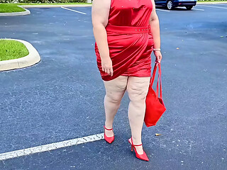 Beautiful woman walking outdoors in public parking lot showing off for strangers