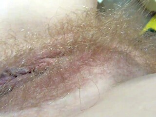 Chubby blonde sits in an armchair exposing her hairy and juicy pink pussy