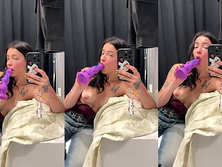 Tattooed brunette teasing with a purple dildo in the mirror at the shop