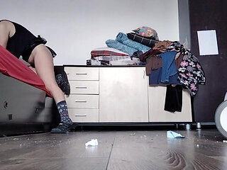 Amateur wife cleans the bedroom with the vacuum cleaner.